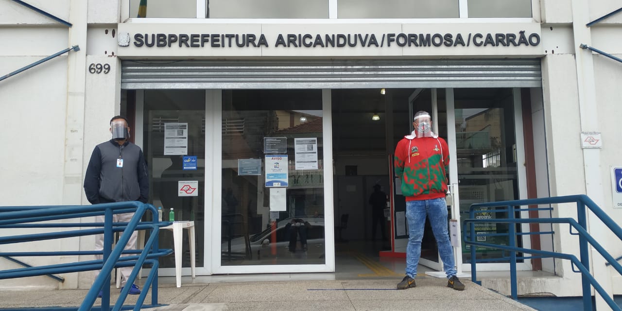 pessoas em frente a subprefeitura protegidos contra o covid